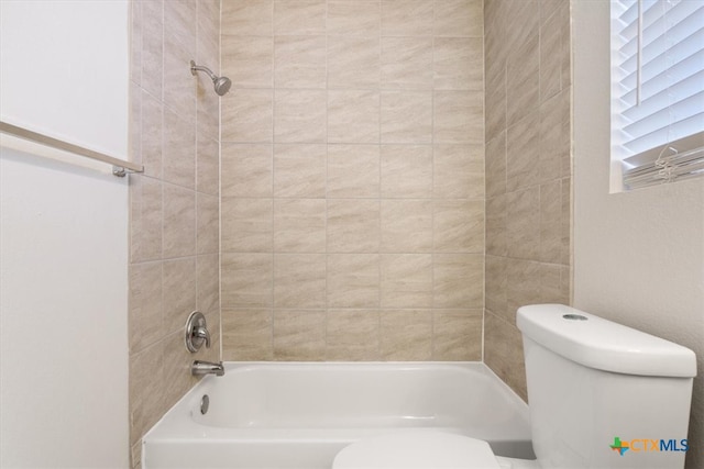 bathroom featuring tiled shower / bath and toilet