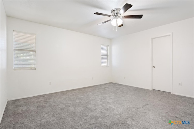 carpeted spare room featuring ceiling fan