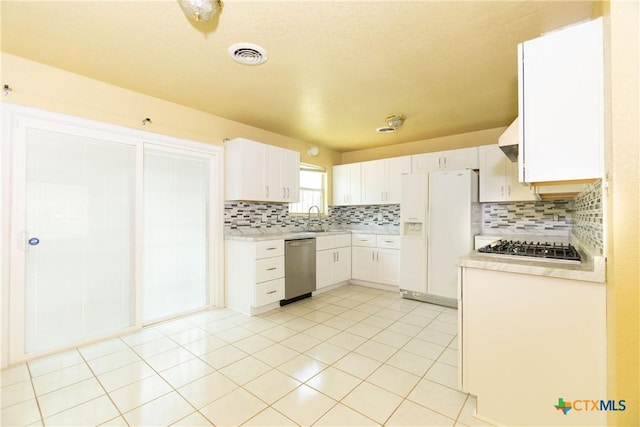 3003 Zephyr Rd, Killeen, TX 76543 - kitchen featuring stainless steel appliances, light countertops, backsplash, white cabinetry, and light tile patterned floors
