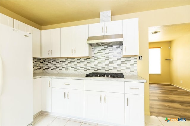 3003 Zephyr Rd, Killeen, TX 76543 - kitchen featuring freestanding refrigerator, wall chimney exhaust hood, gas stovetop, and light countertops