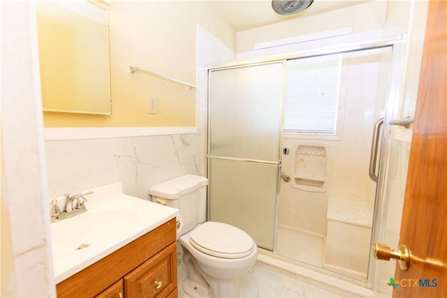 3003 Zephyr Rd, Killeen, TX 76543 - bathroom with a shower stall, vanity, marble look tile flooring, tile walls, and wainscoting