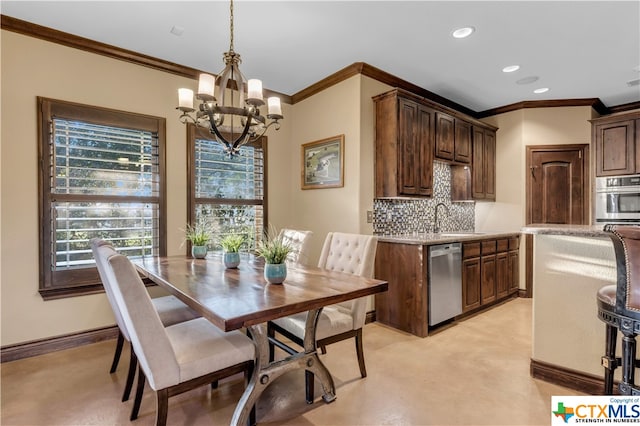 dining area featuring sink, an inviting chandelier, and ornamental molding