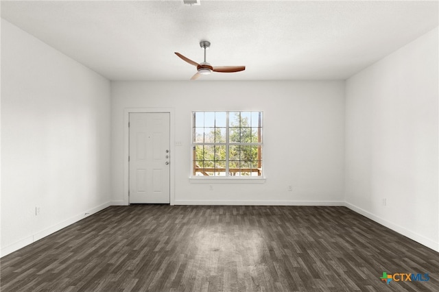 spare room with dark wood-type flooring and ceiling fan