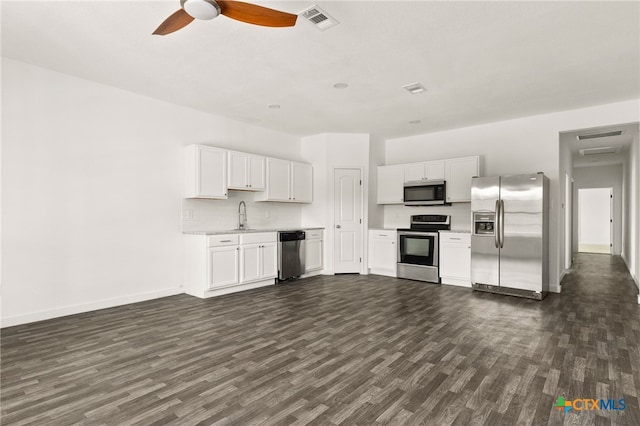 kitchen with dark hardwood / wood-style flooring, white cabinets, sink, and stainless steel appliances