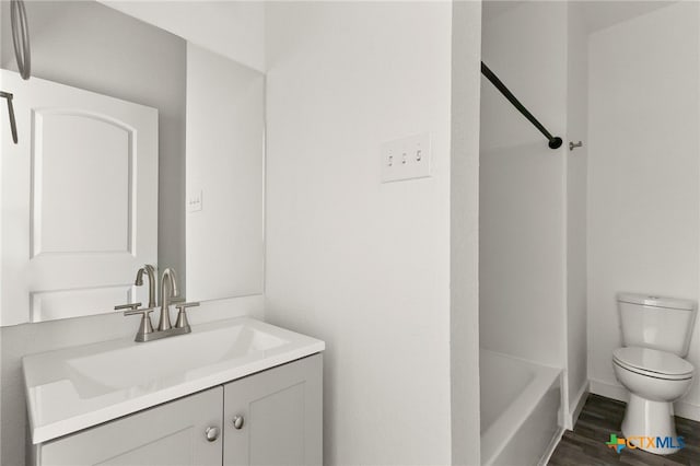 bathroom with toilet, vanity, and hardwood / wood-style flooring