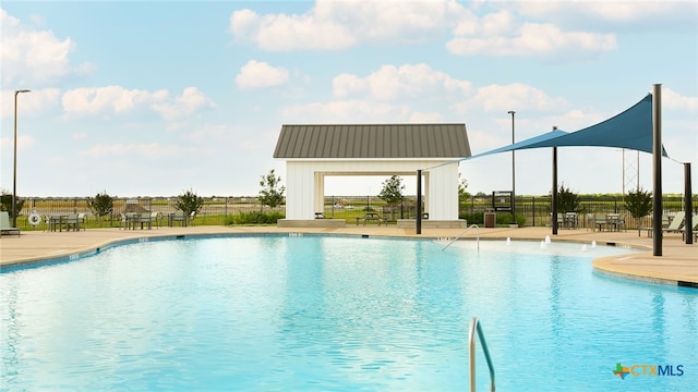community pool featuring fence and a patio