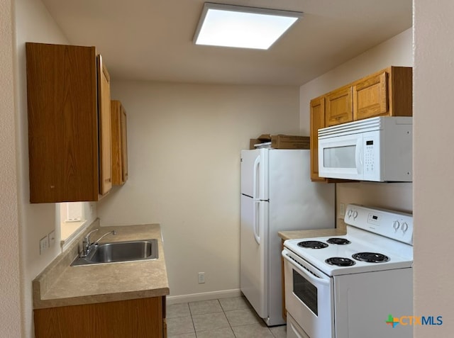 kitchen featuring sink, light tile patterned floors, and white appliances