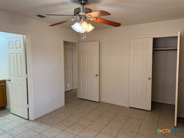 unfurnished bedroom featuring light tile patterned floors, a closet, and ceiling fan