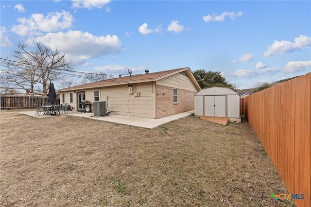 rear view of property featuring a storage unit, central air condition unit, a patio, and a yard