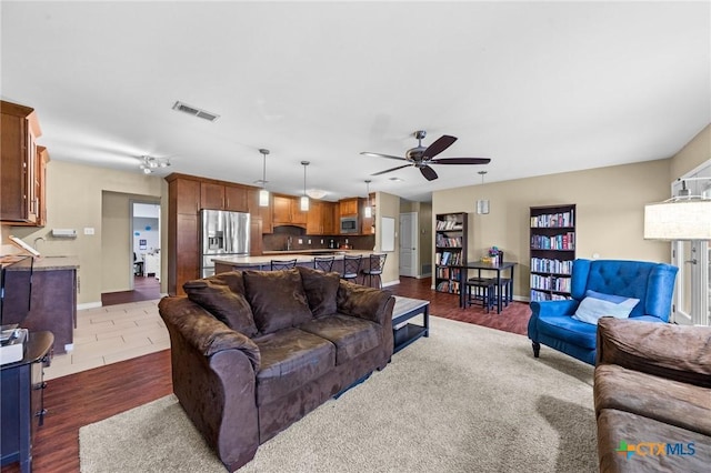 living room with ceiling fan and dark hardwood / wood-style flooring