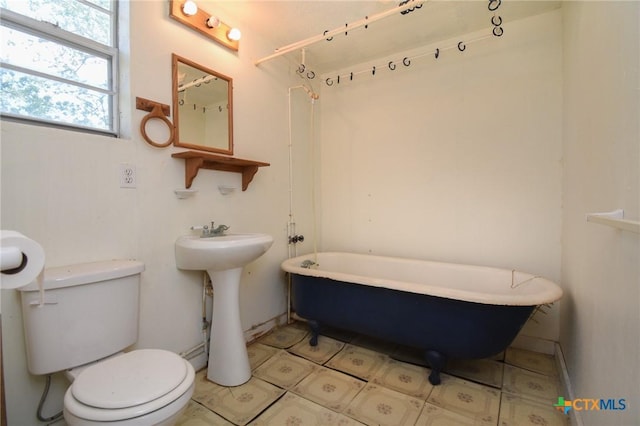 bathroom with a sink, a freestanding bath, and toilet