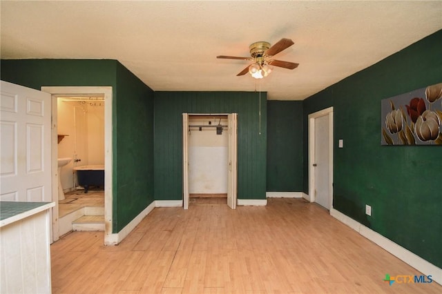 unfurnished bedroom featuring baseboards, ceiling fan, and light wood finished floors