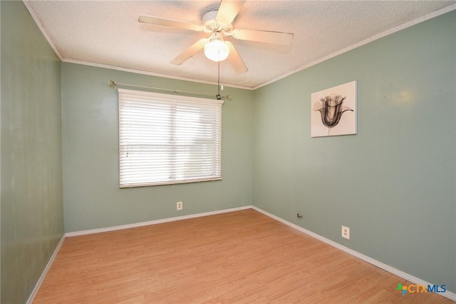 spare room featuring a textured ceiling, ornamental molding, a ceiling fan, and wood finished floors
