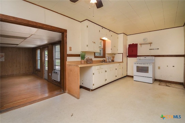 kitchen with wood walls, white range with electric cooktop, light countertops, white cabinetry, and a ceiling fan
