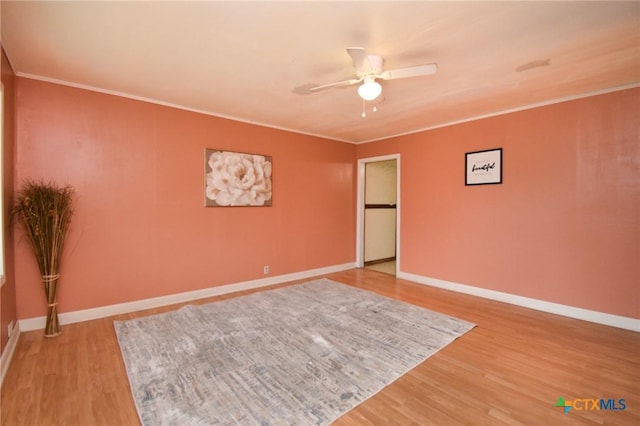 empty room featuring ceiling fan, ornamental molding, baseboards, and light wood-type flooring