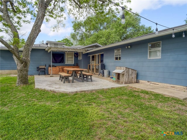 rear view of house with a lawn and a patio
