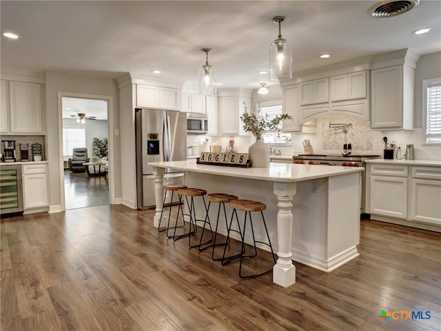 kitchen featuring white cabinets, a wealth of natural light, stainless steel appliances, and visible vents