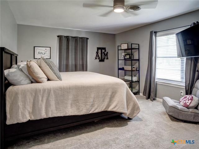 carpeted bedroom with visible vents, baseboards, and ceiling fan