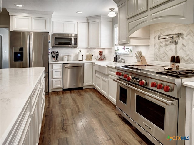 kitchen with white cabinetry, appliances with stainless steel finishes, decorative backsplash, and a sink