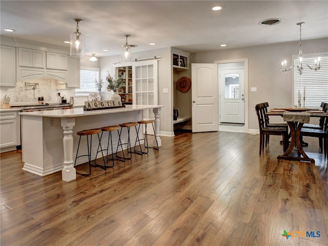kitchen featuring a kitchen island, white cabinetry, dark wood-type flooring, visible vents, and recessed lighting