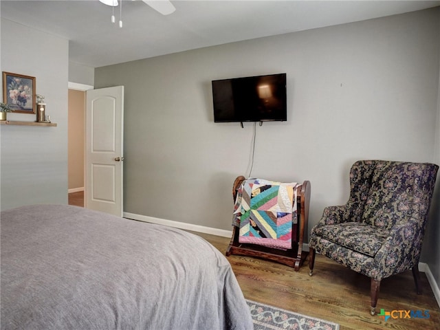 bedroom with ceiling fan, baseboards, and wood finished floors
