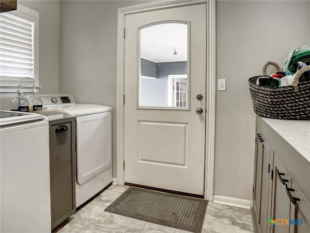 washroom with cabinet space and washer and clothes dryer