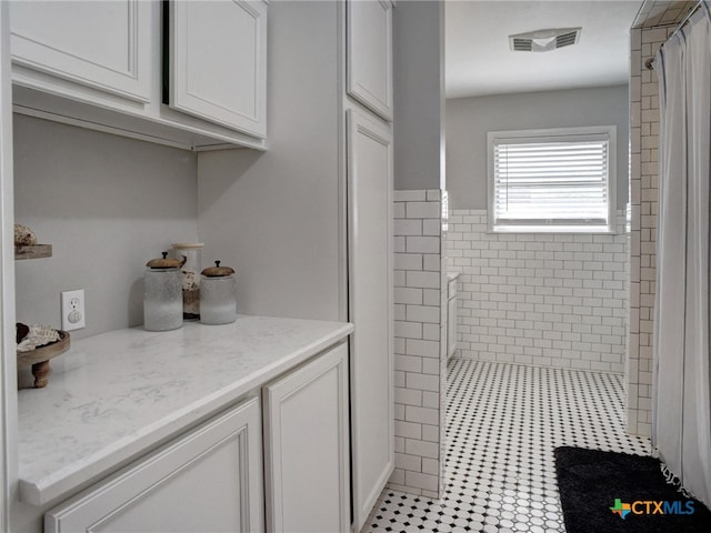 full bath with curtained shower, visible vents, and tile patterned floors