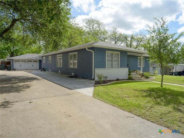 ranch-style home with a front lawn, an outdoor structure, and a detached garage