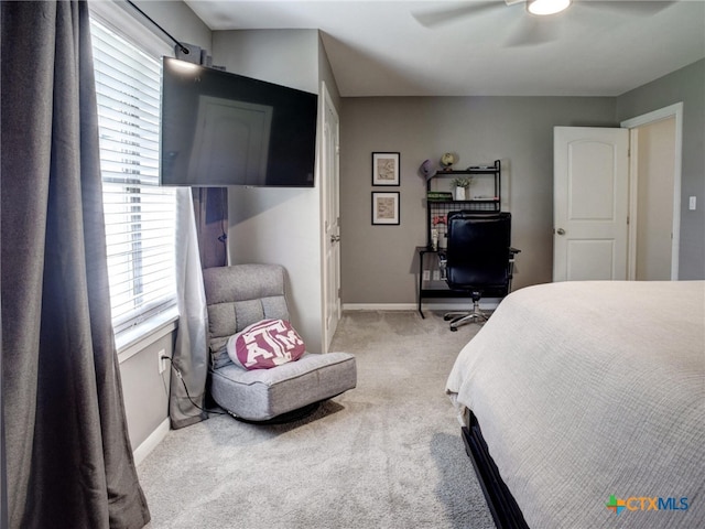 carpeted bedroom with ceiling fan, baseboards, and multiple windows