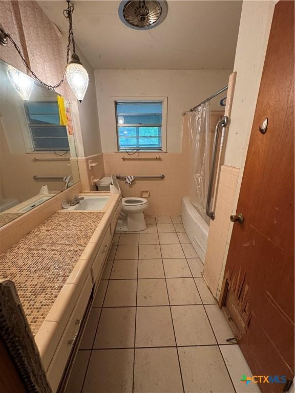 102 E Victory Ave, Temple, TX 76501 - bathroom featuring tile walls, toilet, tile patterned flooring, shower / bath combination with curtain, and vanity