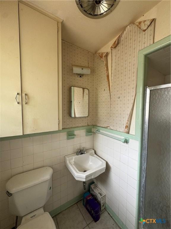 102 E Victory Ave, Temple, TX 76501 - bathroom with a sink, wallpapered walls, toilet, a shower stall, and wainscoting