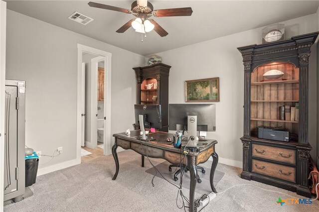 office with visible vents, carpet flooring, baseboards, and a ceiling fan
