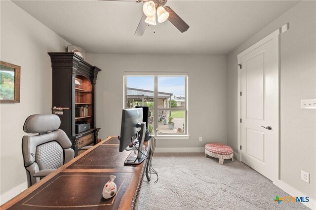carpeted home office with baseboards and a ceiling fan