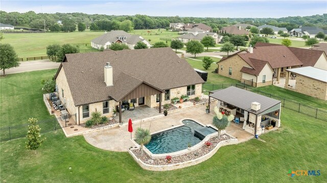 view of swimming pool with a lawn, a patio, a pool with connected hot tub, and a fenced backyard