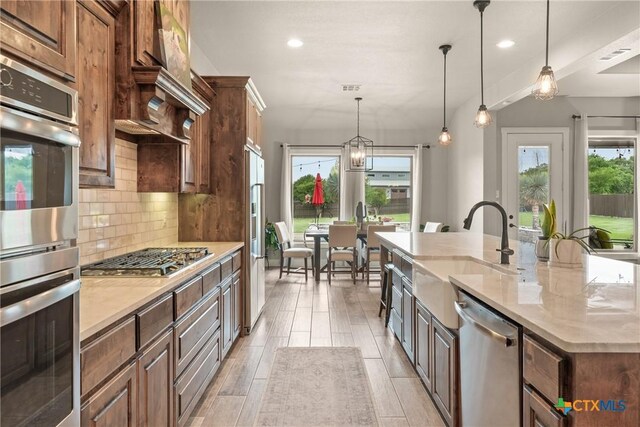 kitchen featuring a large island, appliances with stainless steel finishes, tasteful backsplash, a sink, and recessed lighting
