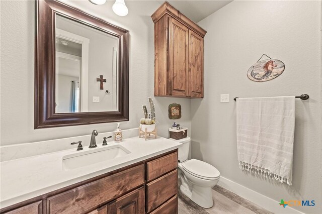bathroom with vanity, toilet, and wood finished floors
