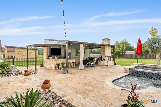 view of patio featuring an in ground hot tub, a fenced backyard, and outdoor dry bar