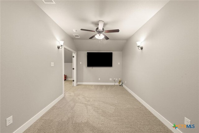 interior space featuring baseboards, ceiling fan, light carpet, and visible vents