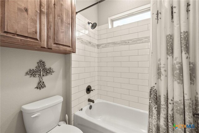 bathroom with shower / bath combination with curtain and toilet