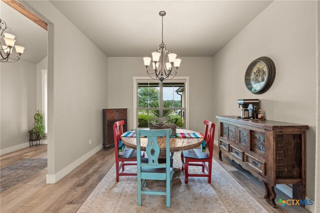 dining room featuring an inviting chandelier, baseboards, and wood finished floors