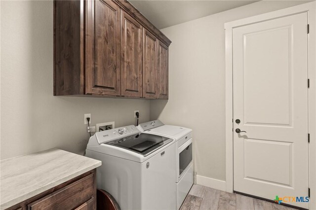 clothes washing area featuring light wood-style floors, cabinet space, independent washer and dryer, and baseboards