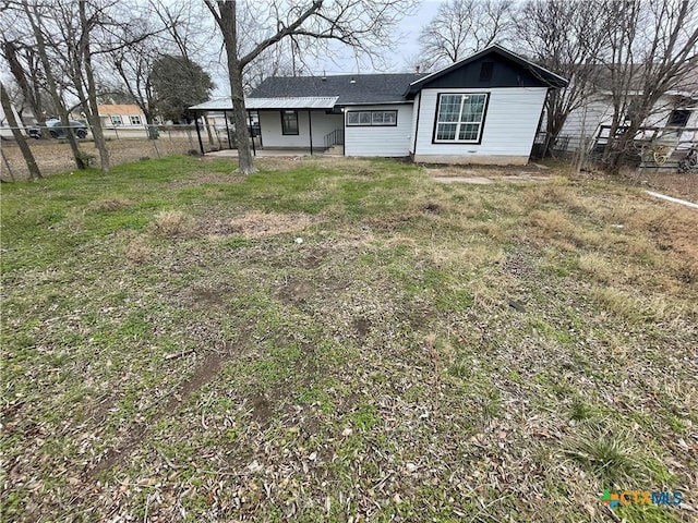 back of house featuring fence and a lawn