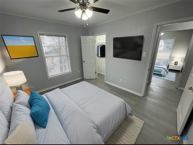 bedroom with ornamental molding, a ceiling fan, baseboards, and wood finished floors