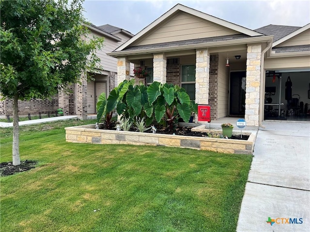 view of front facade with a front lawn, stone siding, and driveway