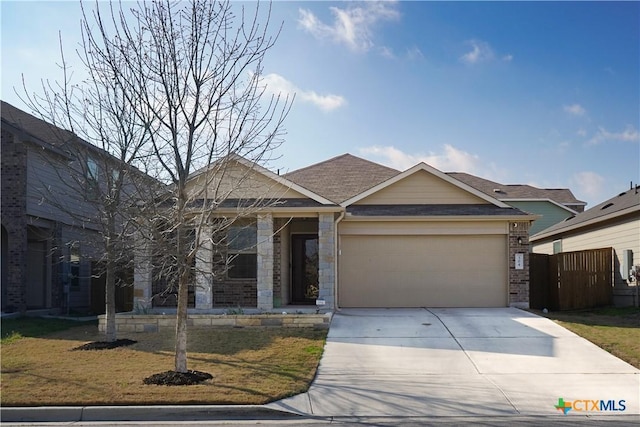 view of front facade with a front lawn, concrete driveway, roof with shingles, stone siding, and an attached garage