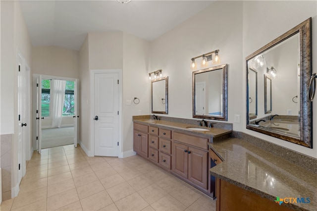 bathroom featuring vanity, vaulted ceiling, and tile patterned flooring