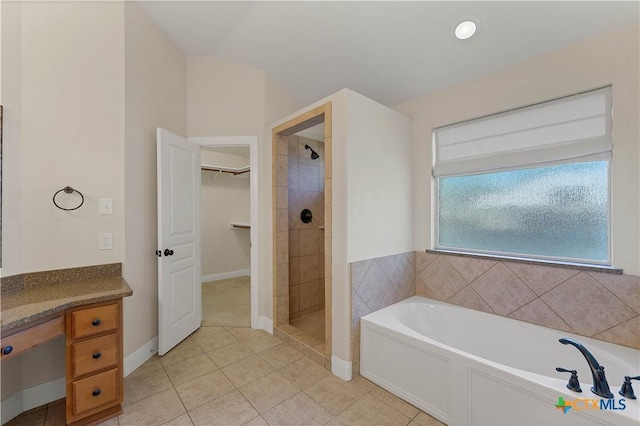 781 Meridian Dr, New Braunfels, TX 78132 - full bathroom featuring a garden tub, a stall shower, tile patterned flooring, a spacious closet, and baseboards