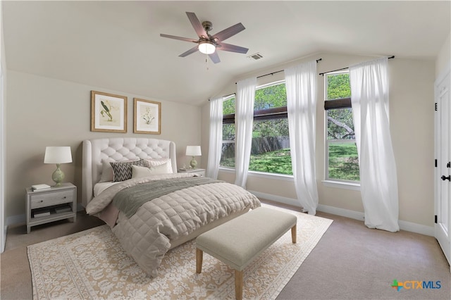 carpeted bedroom featuring ceiling fan, multiple windows, and vaulted ceiling