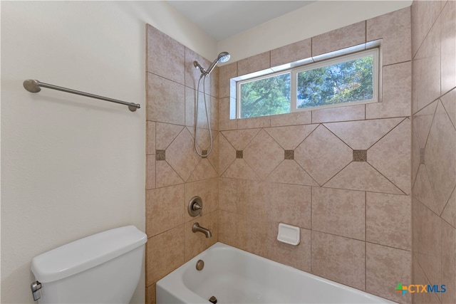 bathroom featuring toilet and tiled shower / bath