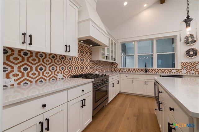 645 Center Grn, New Braunfels, TX 78130 - kitchen featuring stainless steel range, light stone countertops, decorative backsplash, and custom range hood